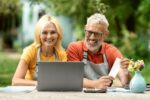 Quick Guide: How To Improve Customer Experience In WooCommerce Portrait of happy senior couple using laptop outdoors in their garden