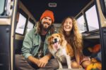 Hipster couple and their dog enjoying a camping adventure on a m