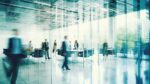 Business people walking in a corridor in a modern office building. Blurred motion background