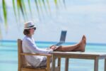Young man with tablet computer during tropical beach vacation