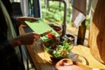 Girl cooking vegetable salad in van