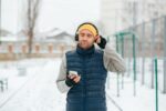 Tech in the Cold Male with Smartphone and Headphones Outdoors