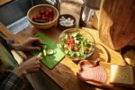 Girl cutting fresh vegetable for salad