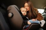 Young mother and child in car. Baby seat on chair. Safety drivin