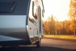 A close – up shot of a modern caravan parked, showcasing the freedom and adventure of travel. Generative AI