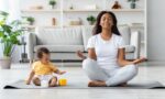 Mental Wellness Concept. Calm Happy Black Mother Meditating With Baby At Home